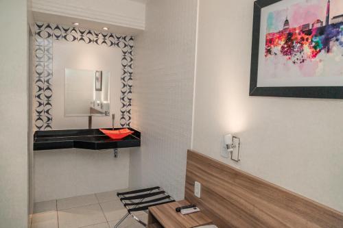 a bathroom with a red sink and a mirror at Hotel Astoria in Palmas