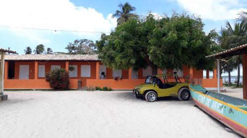 a golf cart parked in front of a house at Pousada Grão de Areia Beira Mar in Mangue Sêco