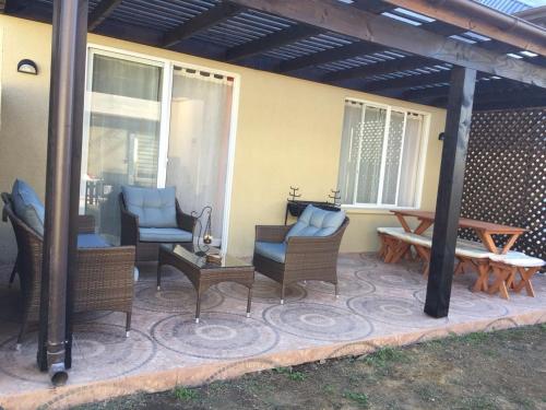 um pátio com cadeiras, mesa e banco em Casa Pucón em Pucón