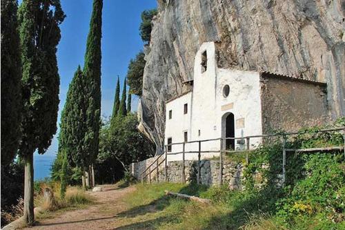 un antiguo edificio en el lado de una montaña en Appartamenti Serena - La Grotta, en Gargnano