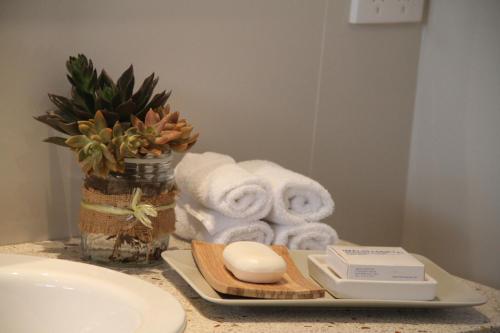 a bathroom counter with towels and a plate with a mirror at Blair Athol Estate Wollombi in Wollombi