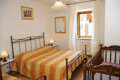 a bedroom with a bed and a mirror and a window at Appartamenti Serena - Nonna Agnese in Gargnano