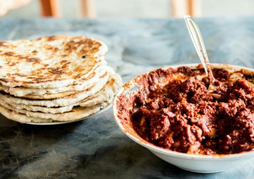 a bowl of salsa next to a stack of pancakes at Tiny Holiday Resort in Dambulla