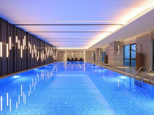 a large swimming pool in a hotel with lights at Wanda Realm Neijiang in Neijiang