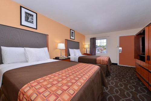ein Hotelzimmer mit 2 Betten und einem Flachbild-TV in der Unterkunft Media Inn & Suites in Media
