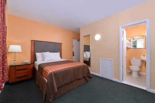 a hotel room with a bed and a toilet at Media Inn & Suites in Media