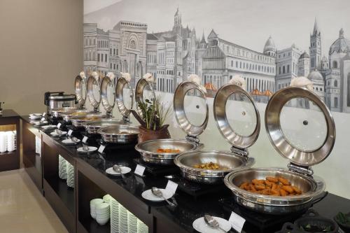 a row of bowls of food on a counter in a room at d'primahotel Kualanamu Airport Medan in Medan