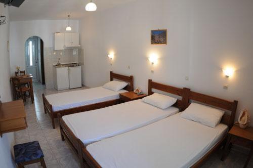 a room with three beds in a room at Dorana Apartments & Trekking Hotel in Diafani