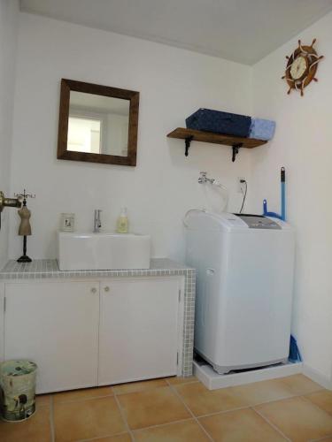 a white bathroom with a sink and a mirror at Vacances a la mer Ishigaki in Ishigaki Island