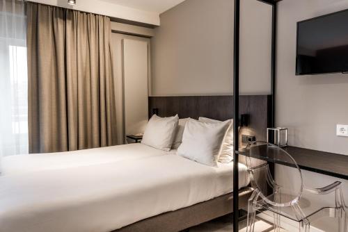 a hotel room with a bed and a glass table at Sandton Eindhoven Centre in Eindhoven