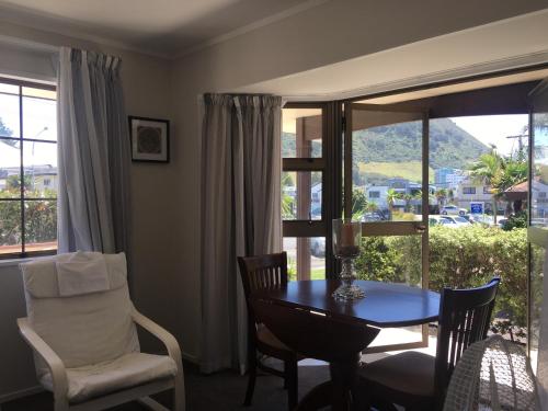 a dining room with a table and chairs and a window at Victoria Road B&B in Mount Maunganui