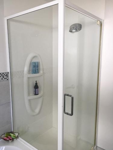 a shower with a glass door in a bathroom at Victoria Road B&B in Mount Maunganui