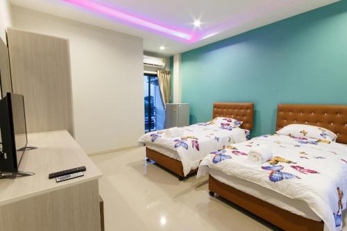 a room with two beds and a tv in it at Bangwua Garden Resort in Ban Bang Chak