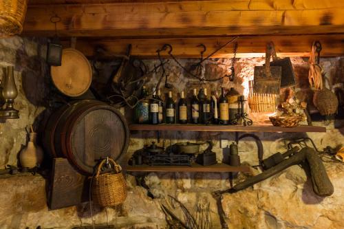 a wall with shelves with bottles of wine andartifacts at Country House Bakicevo in Čilipi