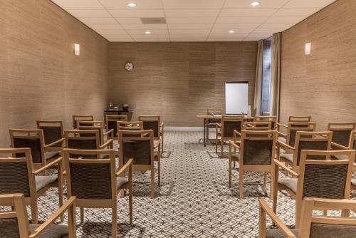 an empty room with tables and chairs and a whiteboard at Sandton Eindhoven Centre in Eindhoven