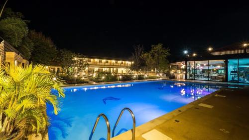 a large blue swimming pool at night at AU Place Hotel in Loei