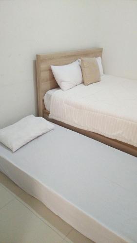 two beds sitting next to each other in a room at Wika Bali Beach House in Jimbaran