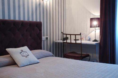 Hôtel de L'Avenue في سانت: غرفة نوم مع سرير ومكتب مع مصباح
