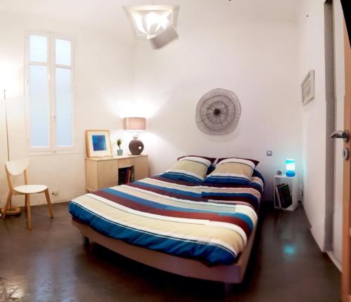 une chambre avec un lit dans une pièce blanche dans l'établissement Your Home in Marseille***, à Marseille