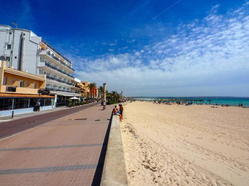 a beach with people walking on the sand and the ocean at Sauló by Puro in Can Pastilla