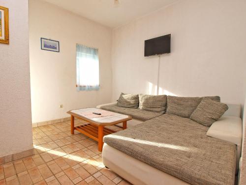 ein Wohnzimmer mit einem Sofa und einem Tisch in der Unterkunft Apartments Ivo 1328 in Fažana