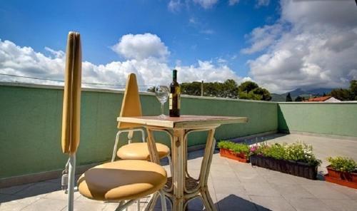 a table and two chairs and a bottle of wine on a balcony at Villamir B&B in Albenga