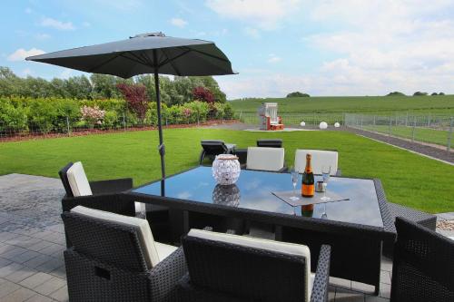 uma mesa com um guarda-chuva num pátio em Ferien_VILLA PACE em Göhren-Lebbin