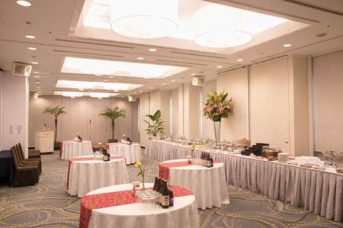 a banquet hall with tables with white table cloth at Laguna Garden Hotel in Ginowan