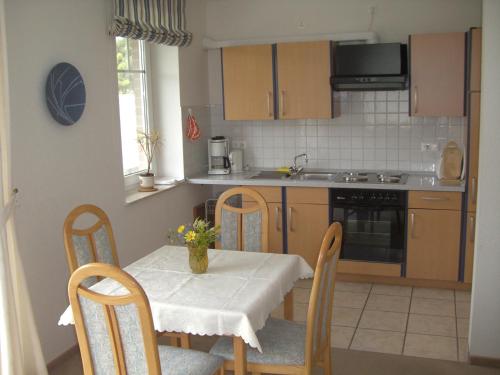 a kitchen with a table and chairs and a kitchen with a sink at Ferienwohnungen Lindemann in Jork