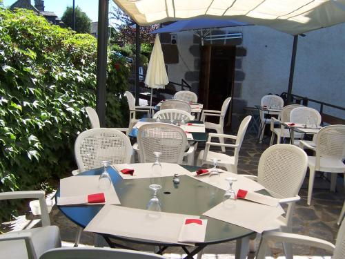 a group of tables and chairs sitting on a patio at Auberge Hôtel de Tournemire - Cantal in Tournemire
