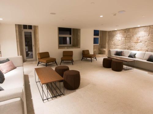 a living room with a couch and tables and chairs at Hotel Carris Porto Ribeira in Porto