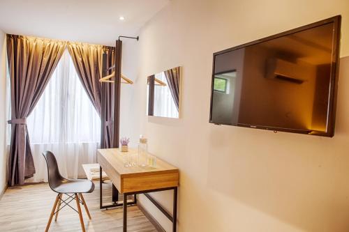 a room with a table and a television on a wall at The Marion Hotel in Johor Bahru