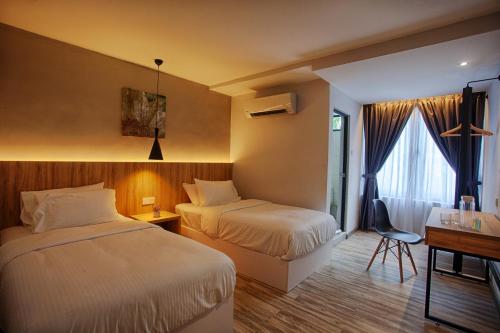 ein Hotelzimmer mit 2 Betten und einem Schreibtisch in der Unterkunft The Marion Hotel in Johor Bahru