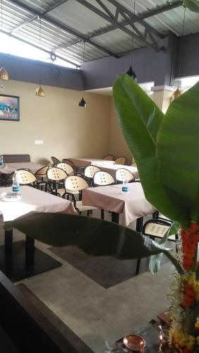 a group of tables in a room with chairs at Navaratna Palace in Belgaum