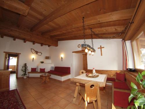 una sala de estar con una mesa y una cruz en la pared en Bauernhof Leneler, en Arzl im Pitztal
