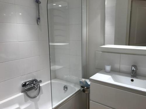une salle de bain blanche avec une douche et un lavabo dans l'établissement Alouette, à Cannes