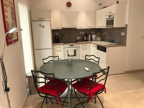 une cuisine avec une table et des chaises et une cuisine avec des armoires blanches dans l'établissement Alouette, à Cannes
