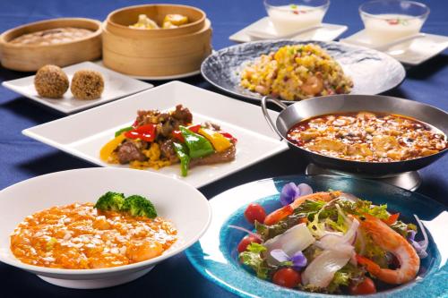 a table with plates of food and bowls of food at Laguna Garden Hotel in Ginowan