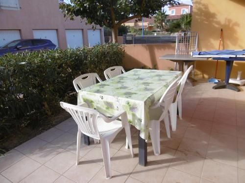 une table et des chaises assises sur une terrasse dans l'établissement Holidayland Residence Plein Sud villa 60m2 6 couchages, à Narbonne-Plage