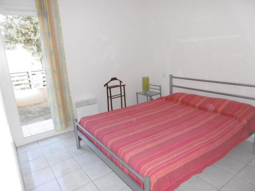 1 dormitorio con 1 cama con manta a rayas en Holidayland Residence Plein Sud villa 60m2 6 couchages, en Narbonne-Plage