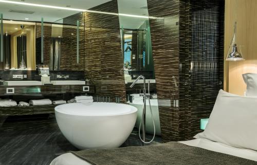 拿坡里的住宿－ROMEO Napoli，一间带大浴缸和大镜子的浴室
