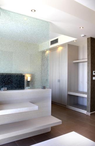 a bathroom with white counters and a glass wall at Sea Melody Beach Hotel Apartments in Ialysos