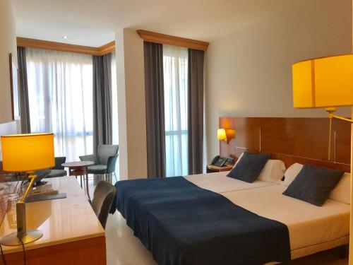 a hotel room with a large bed and a desk at Hotel Calasanz in Molins de Rei