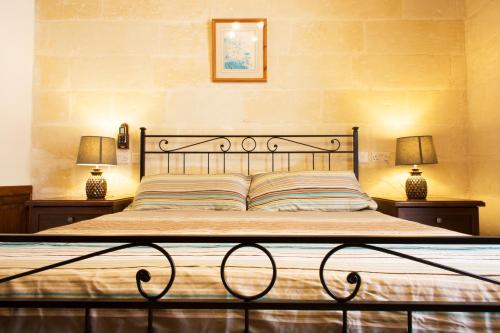 1 cama en un dormitorio con 2 lámparas en las mesas en Maltese Town House Sliema, en Sliema