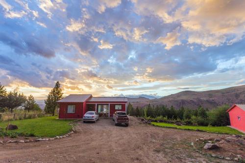 a house with a car parked in front of it at Cabañas La Lila in Huinganco