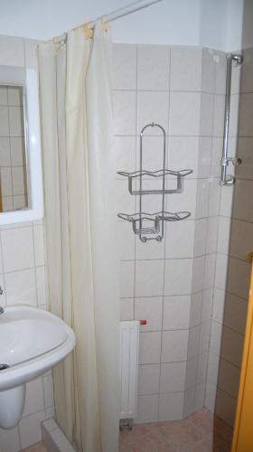 a bathroom with a shower curtain and a sink at Judit Panzio in Gyulakeszi