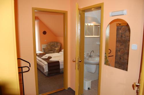 1 dormitorio con 1 cama y baño con lavabo. en Judit Panzio, en Gyulakeszi