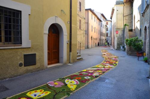 an alley with flowers painted on the side of a building at Antica Dimora delle Acque in Cannara