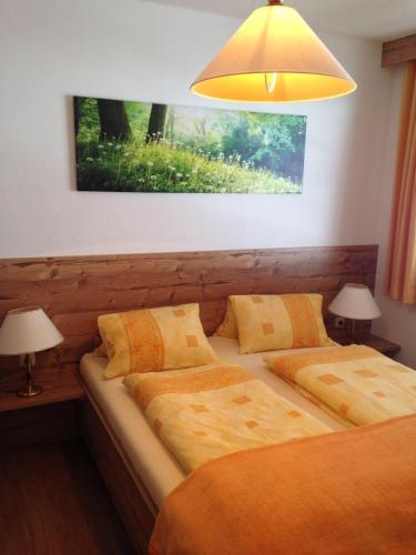 a bedroom with two beds and a yellow lamp at Ferienwohnungen Obex in Mieders