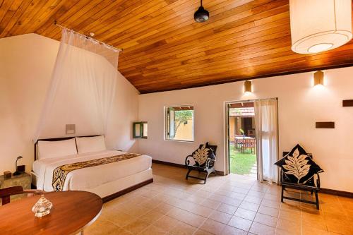a bedroom with a bed and a wooden ceiling at Jetwing Ayurveda Pavilions in Negombo